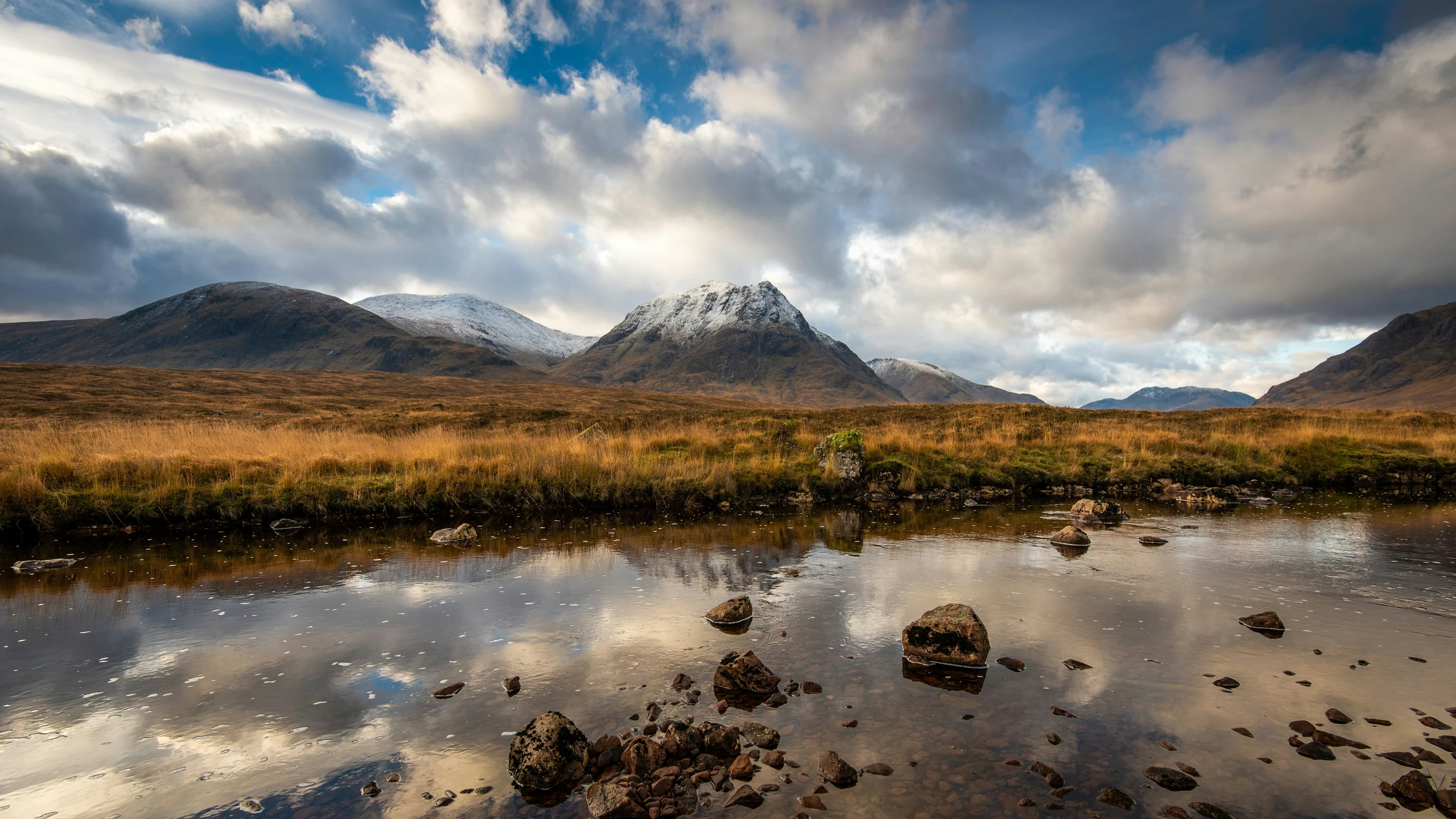 a mountain range behind some small lakes