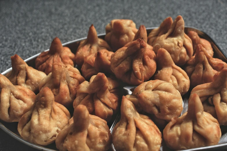 some little pastries in a metal tin are displayed