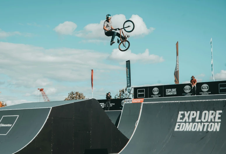 a man is doing tricks on a bicycle over a ramp