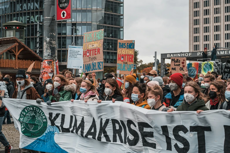 several protesters in masks hold up a banner