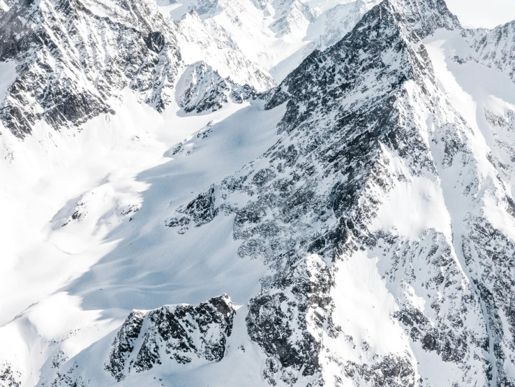 snowy mountain peaks with a cloudy sky in the background