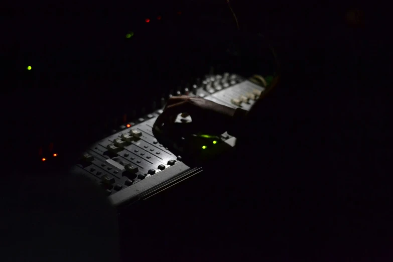 a person is looking down at a mixing console