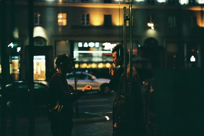 some people talking next to some buildings at night