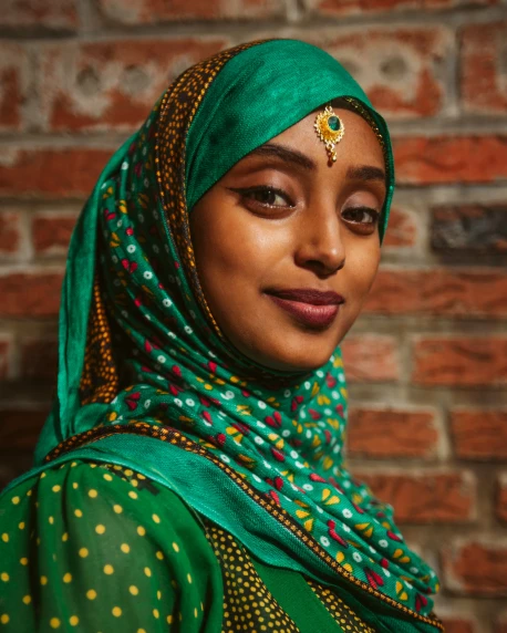 a woman wearing a green veil and a gold necklace
