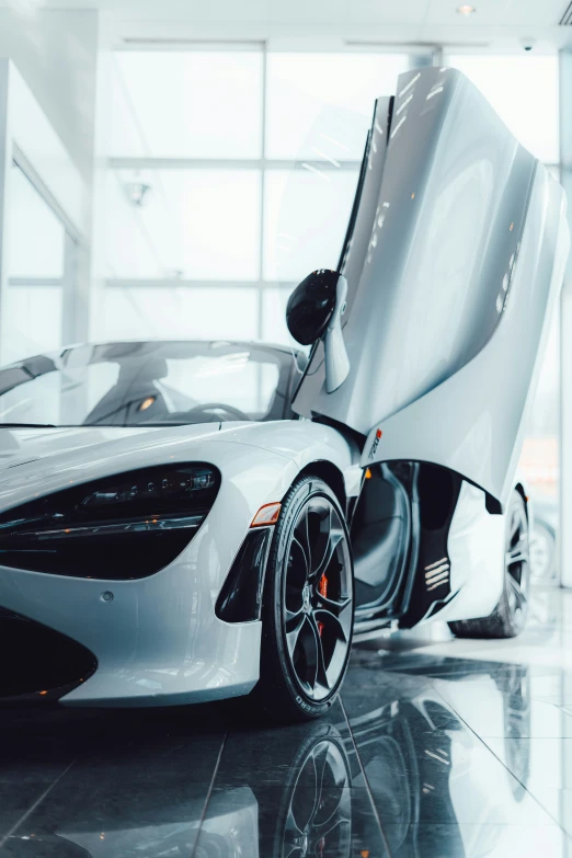 two cars in a large room with windows and white paint