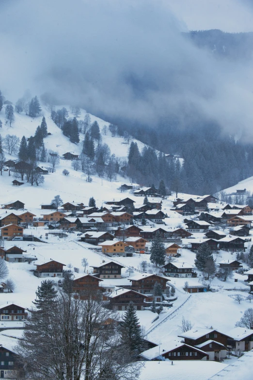 a snow covered hill with houses in the distance