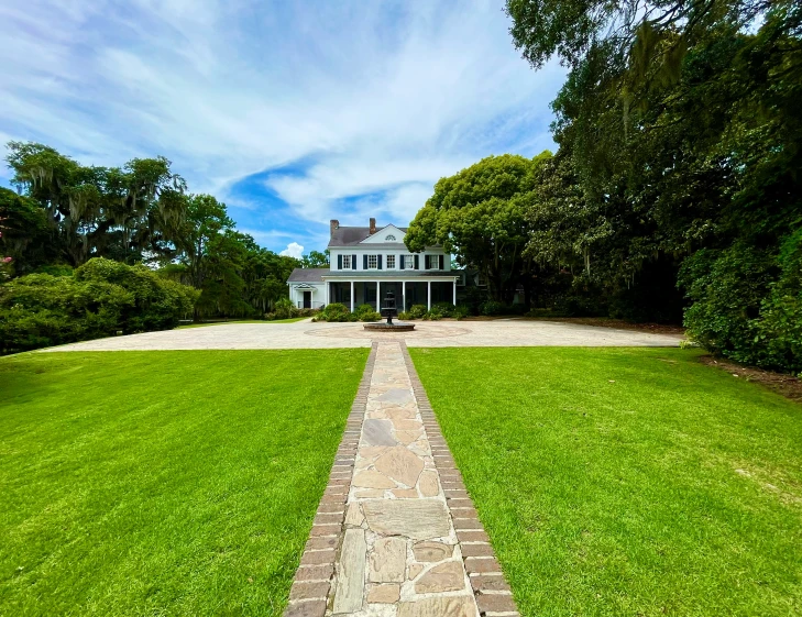 a beautiful brick path with a white house in the distance