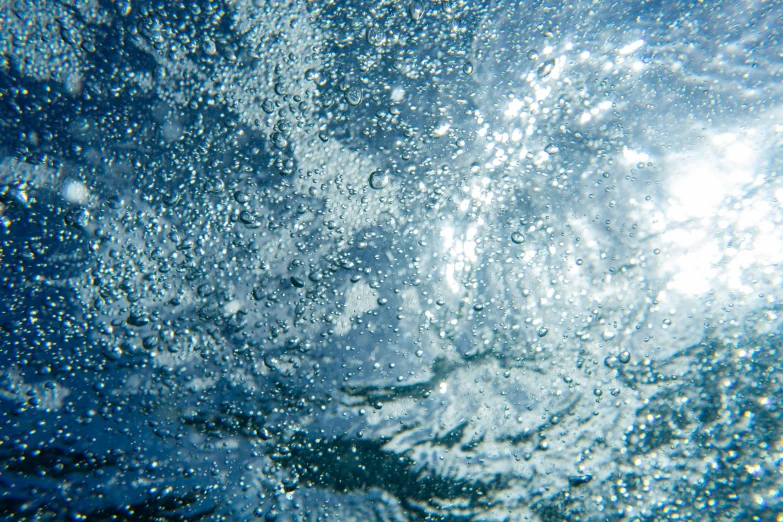 bubbles over a blue ocean surface making them look like they are going to splash