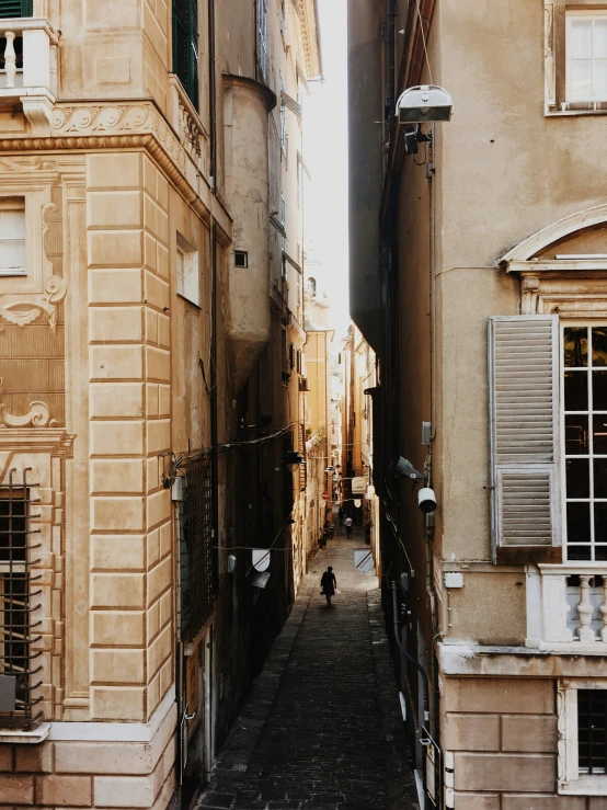 an alley with brick buildings and tall shutters