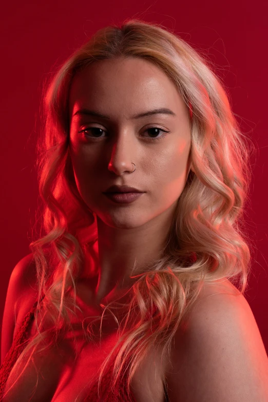 a woman is posing in front of a red background