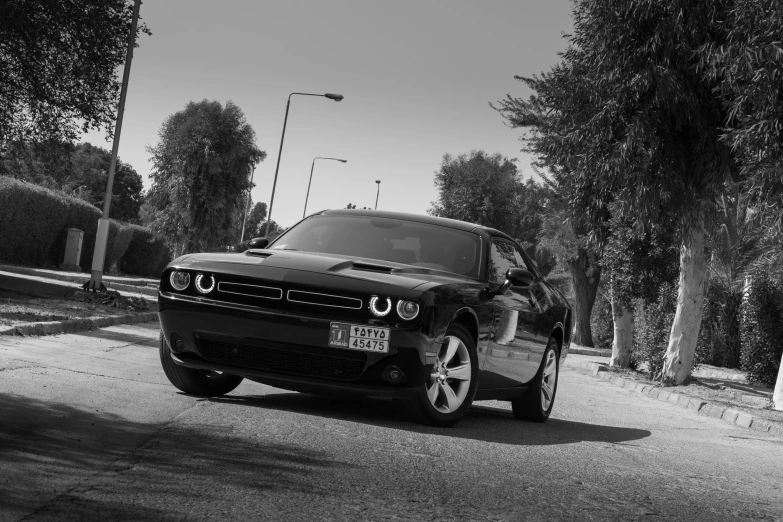 a car with headlights and bumper guards is parked near a street