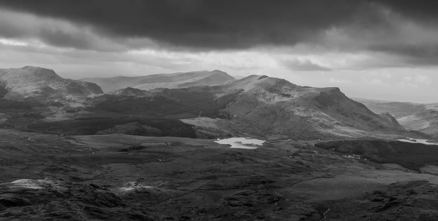 black and white po of mountains under a storm