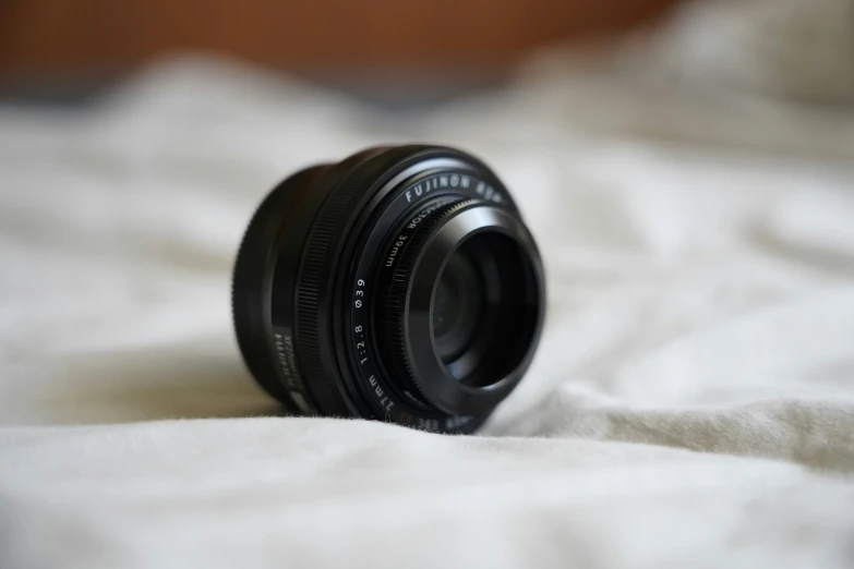 a small camera lens is laying on a white cloth