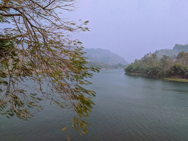 river and hill covered by mist during the day