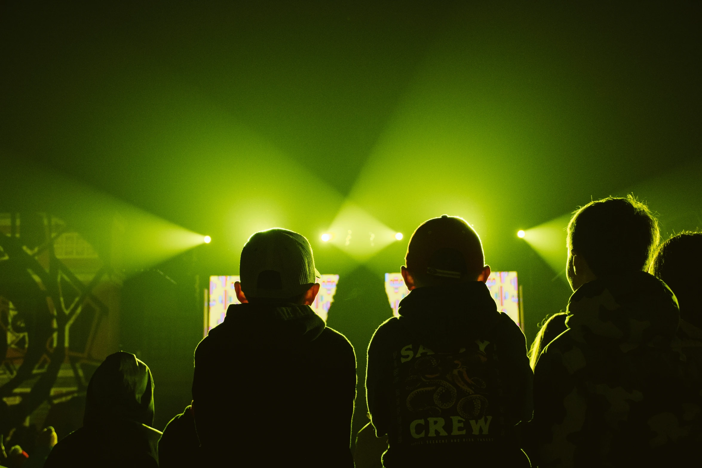 people standing in front of two lights on stage