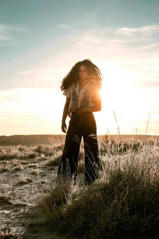 the person is walking across a prairie near a grassy field