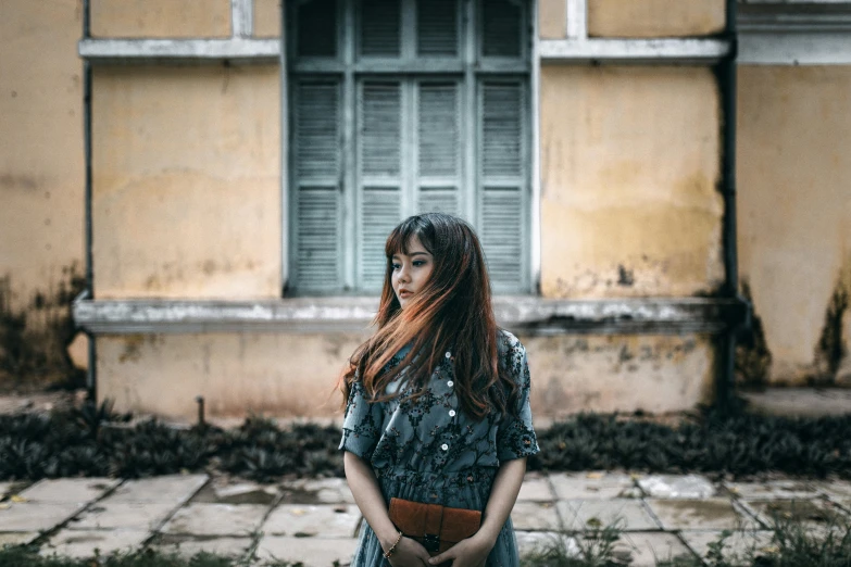 a woman standing in front of a building with a purse