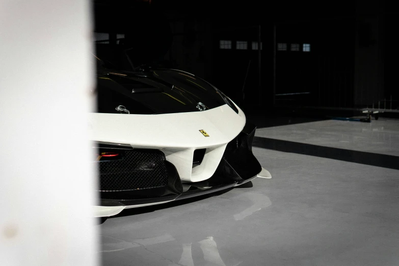 a sports car parked in a garage next to another sports vehicle