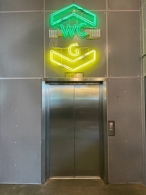 an elevator with neon signage above the doors