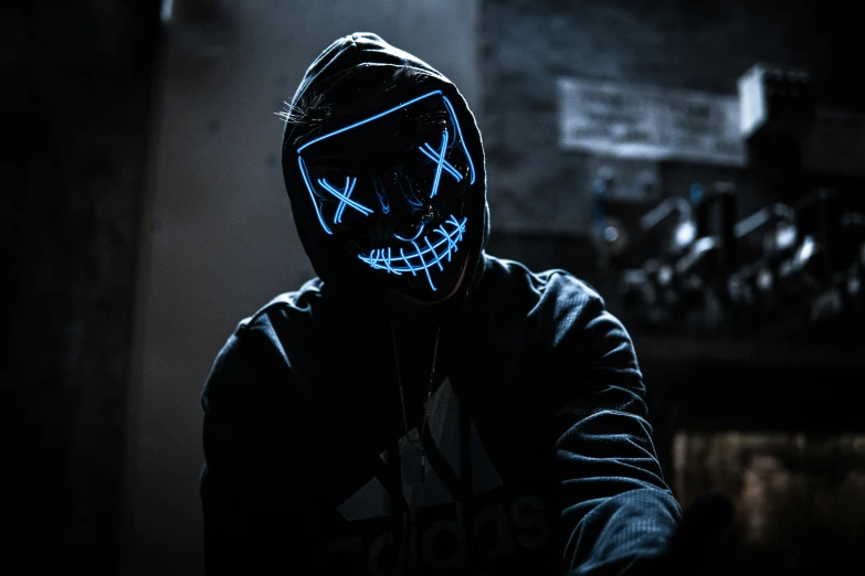 the man is wearing a mask with blue light on his face