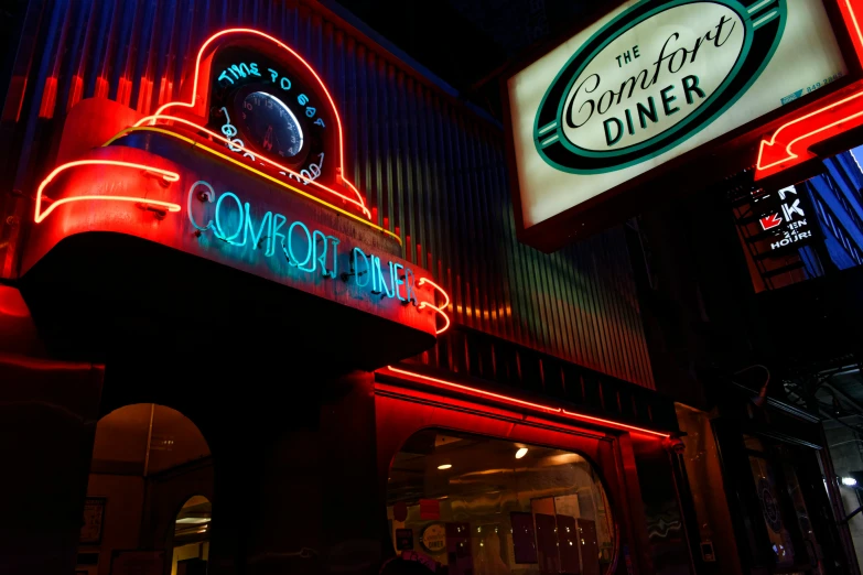 a large illuminated neon sign next to a restaurant