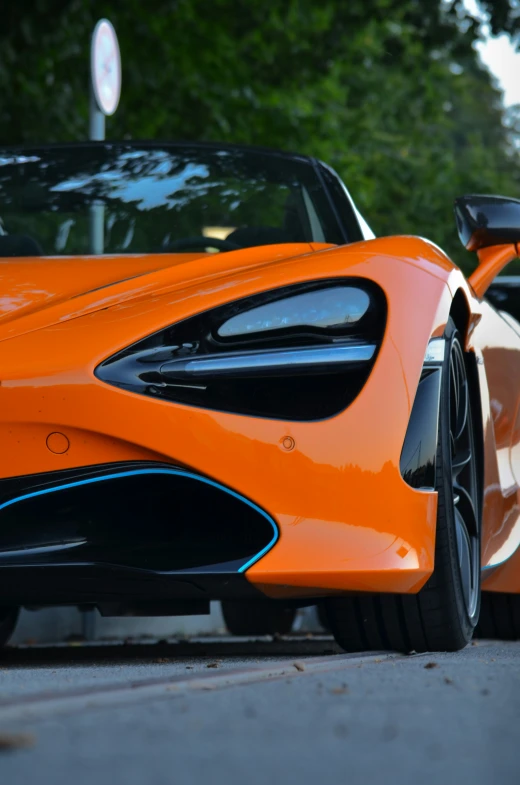 an orange and black car driving down the street