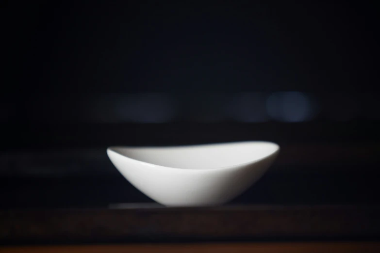 a white bowl sitting on top of a wooden table