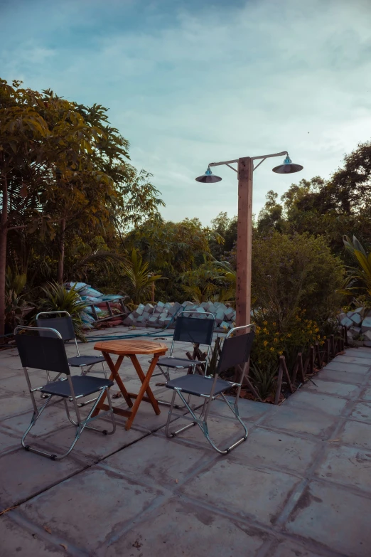 an outdoor table and chairs under an outdoor lamp post