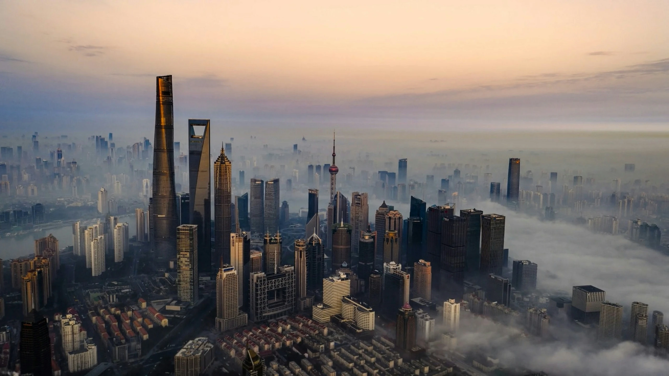 an aerial po shows the tops of skyscrs and clouds