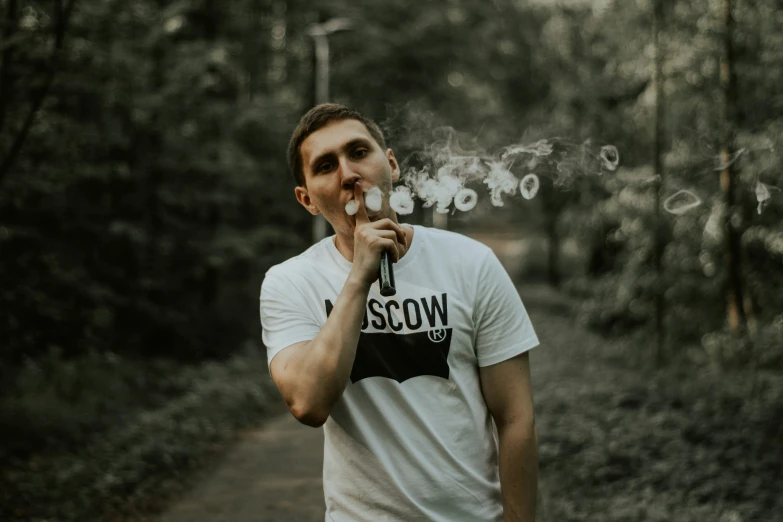 a young man smoking with a cigarette in his mouth