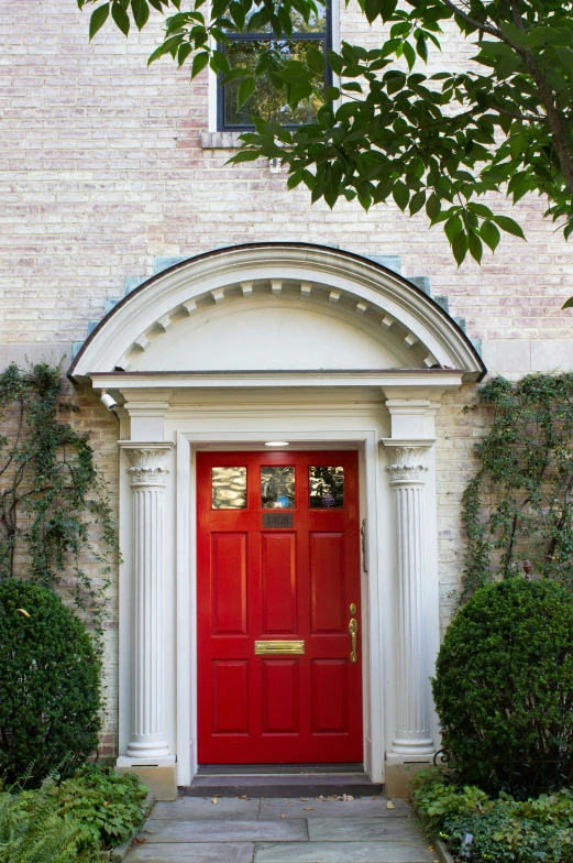a red front door is on an elegant home