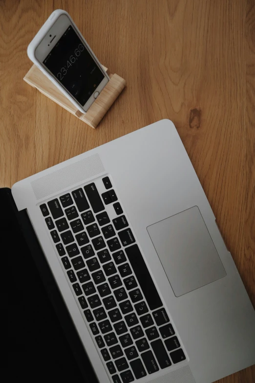 a laptop, phone and a cup sitting on a table