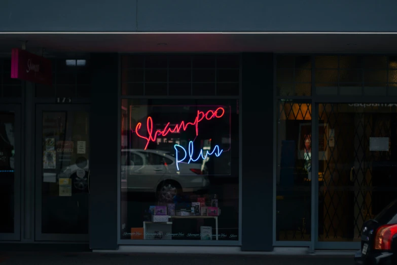 the window of a business with a neon sign