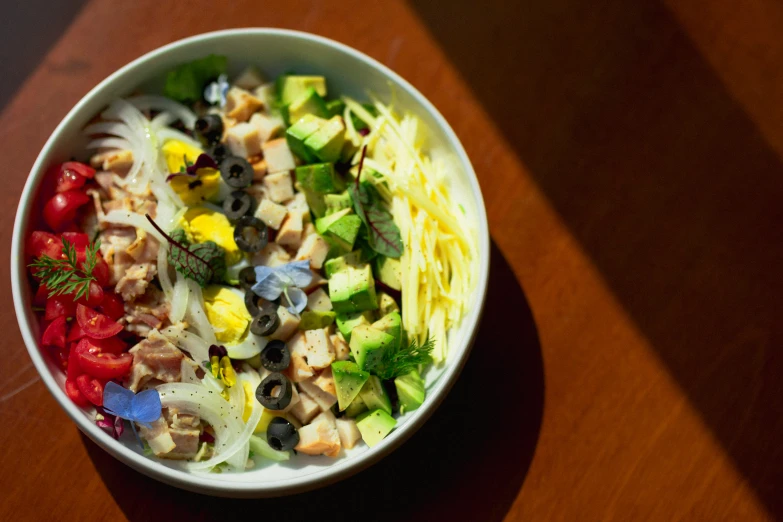 a bowl of salad sitting on top of a table