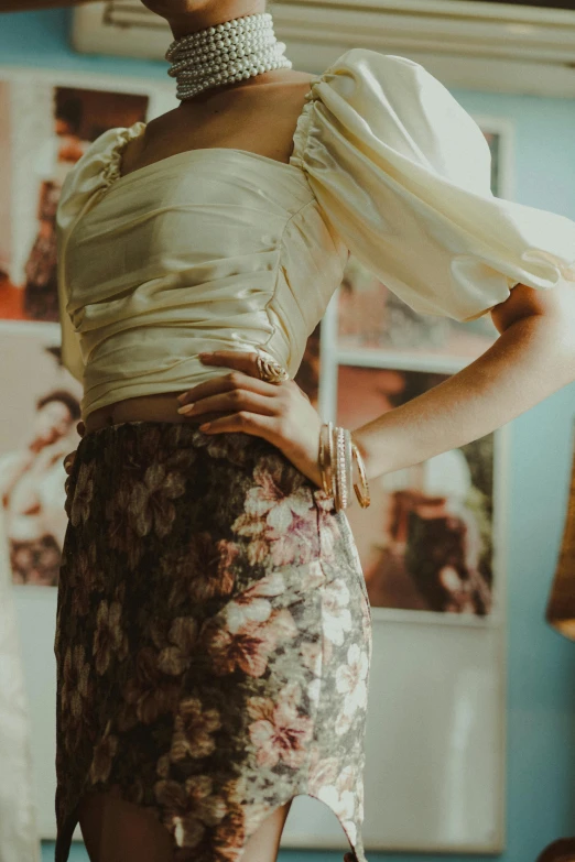 a model wears an unusual dress and pearl necklace