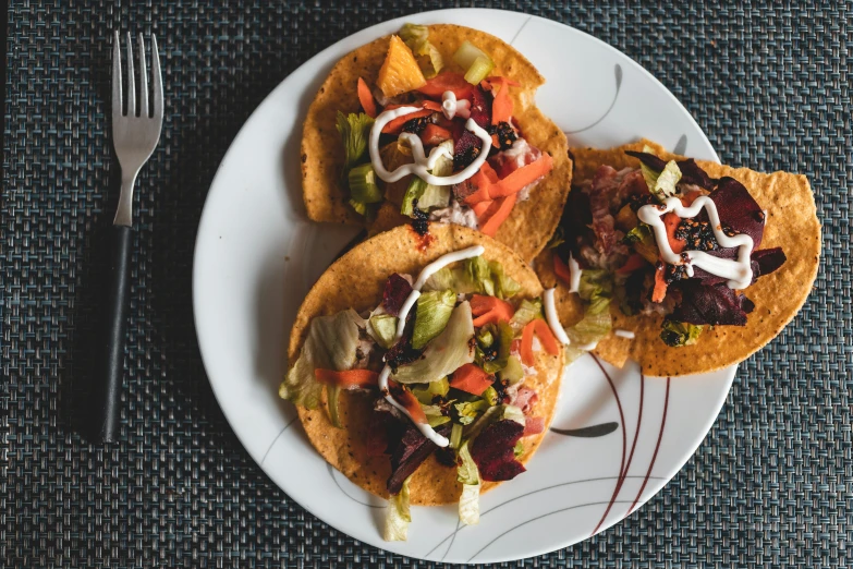 a plate that has some tacos and a fork on it