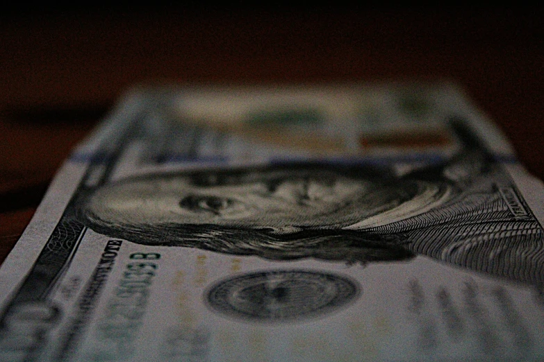 one dollar is displayed on a black table