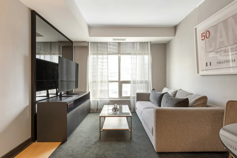 a clean living room with grey carpet and gray walls