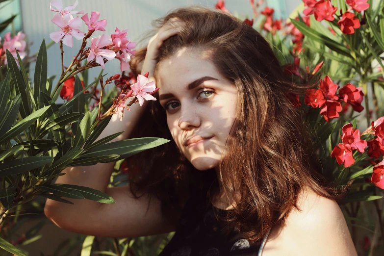 a woman standing next to flowers posing for a picture