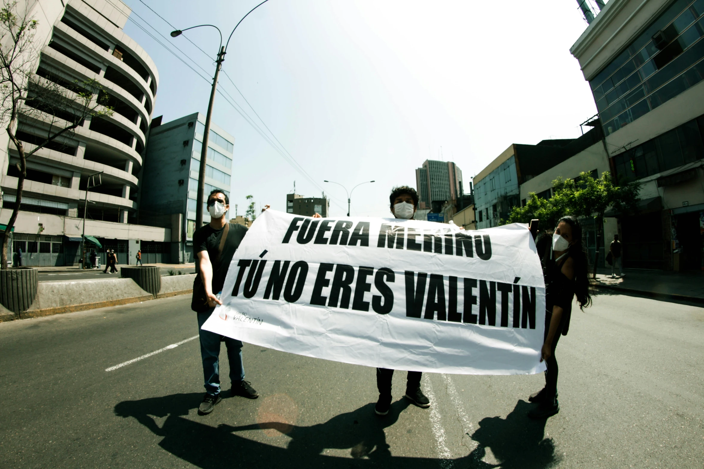 people holding a banner and walking on the street