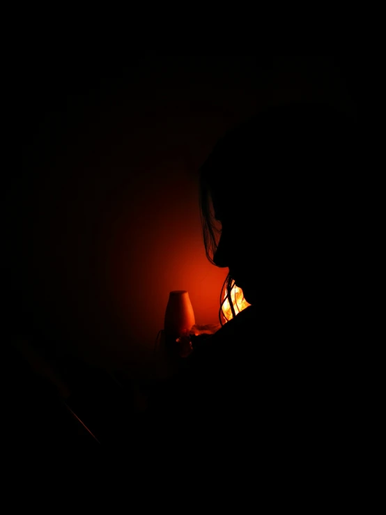 a man who is sitting by some kind of lamp