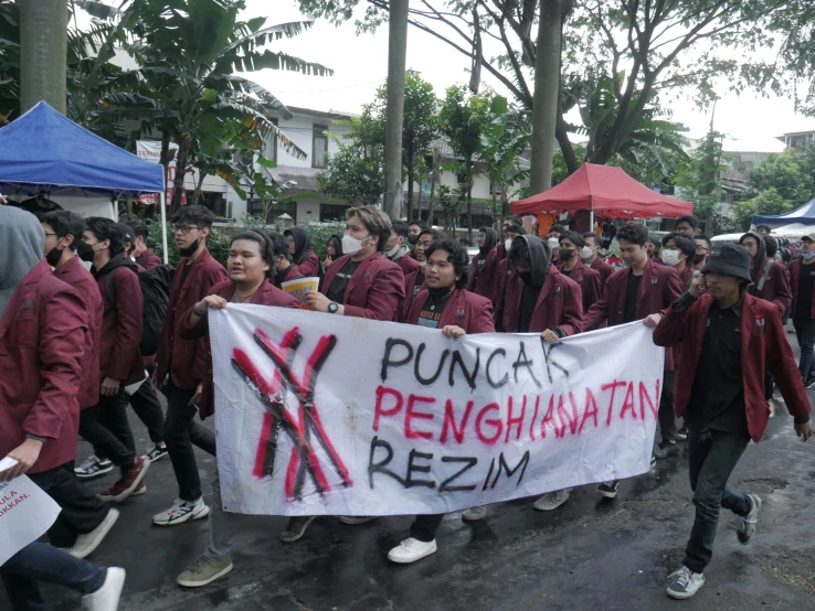 people marching in the street in protest with their banner