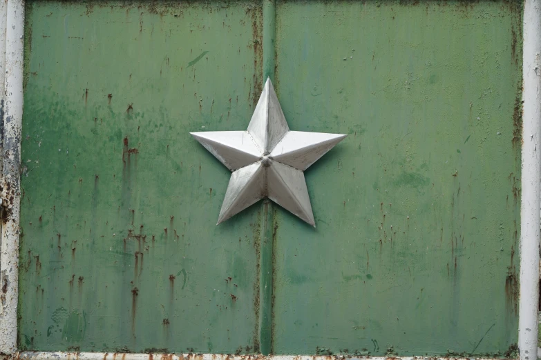 metal sculpture displayed on green painted wall,