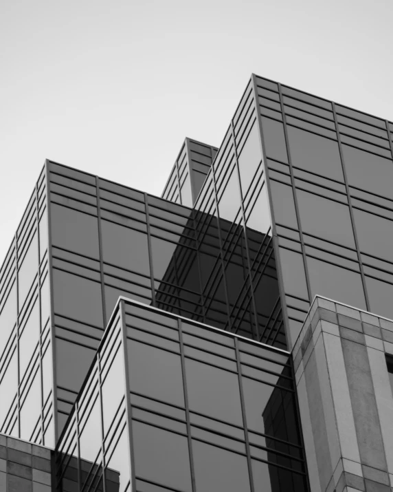 an airplane flies past some modern glass buildings