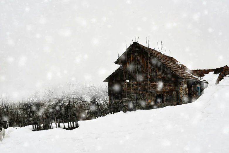 a wooden cabin is standing on the snow covered hills