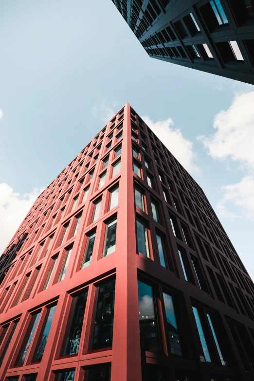 looking up at a tall red building with multiple windows