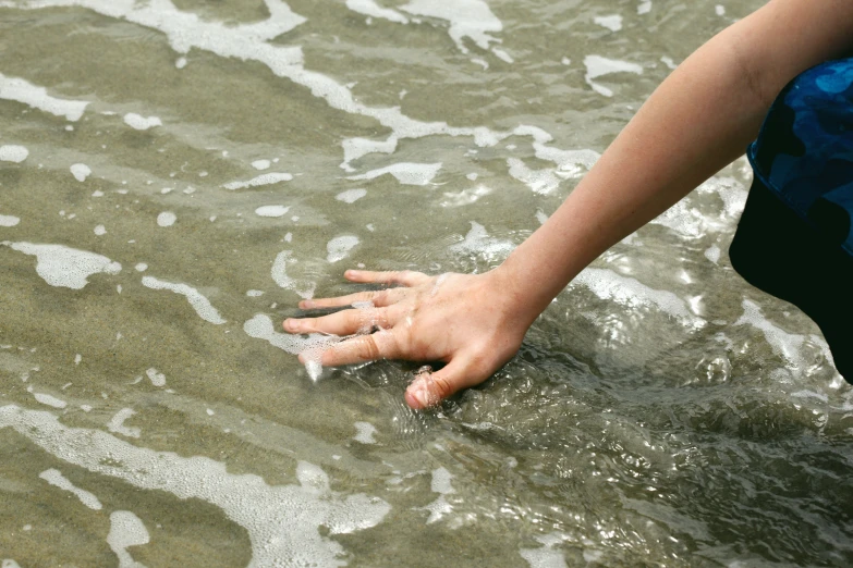 a hand is sticking soing out of the water
