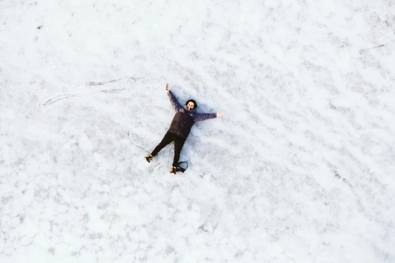 person standing in snow and wearing black with their hands on their hips