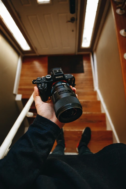 the person is holding a camera up on a set of stairs