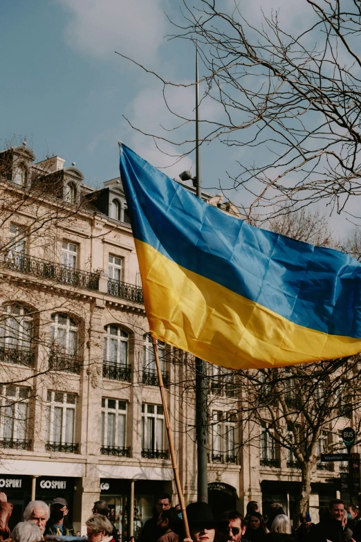 a ukraine flag is waving in the wind on the street